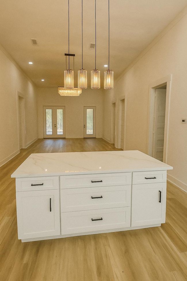 Kitchen with light wood-style flooring, white cabinetry, french doors, hanging light fixtures, and recessed lighting(AI staged) | Image 10