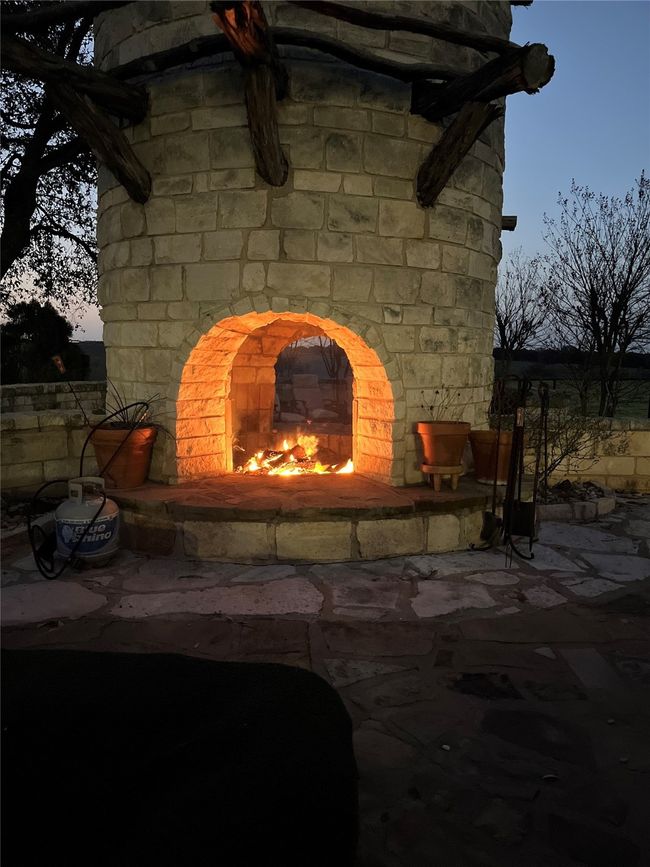 Exterior details featuring a lit fireplace | Image 35
