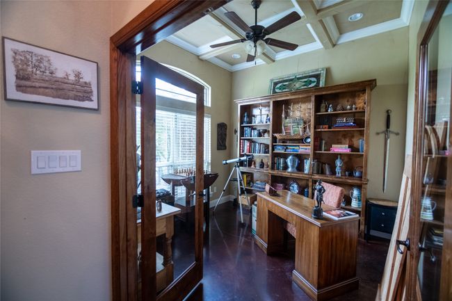 Office with ceiling fan, coffered ceiling, concrete floors, baseboards, and beam ceiling | Image 7