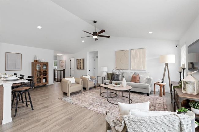 Living room featuring light hardwood / wood-style flooring, vaulted ceiling, and ceiling fan | Image 7