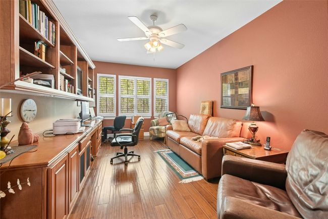 Office space with a ceiling fan and light wood-type flooring | Image 12