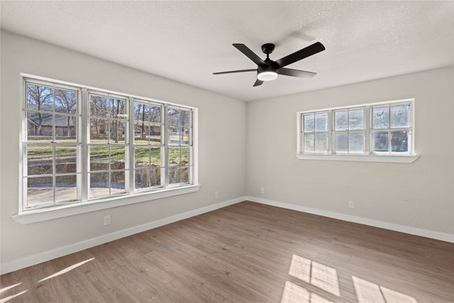 Spare room featuring light wood-type flooring, ceiling fan, baseboards, and a textured ceiling | Image 9