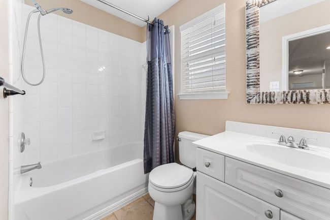 Bathroom featuring shower / tub combo, vanity, toilet, and tile patterned floors | Image 27