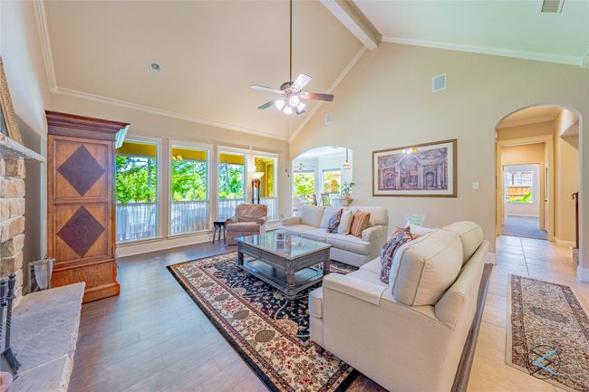 Living room featuring ceiling fan, beam ceiling, crown molding, and high vaulted ceiling | Image 22