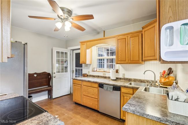 Kitchen featuring a ceiling fan, stainless steel appliances, and a sink | Image 13