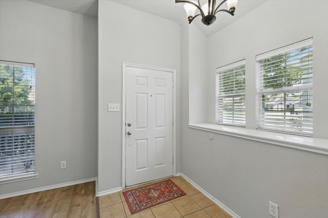 Foyer entrance featuring a chandelier, lofted ceiling, and light tile patterned floors | Image 6