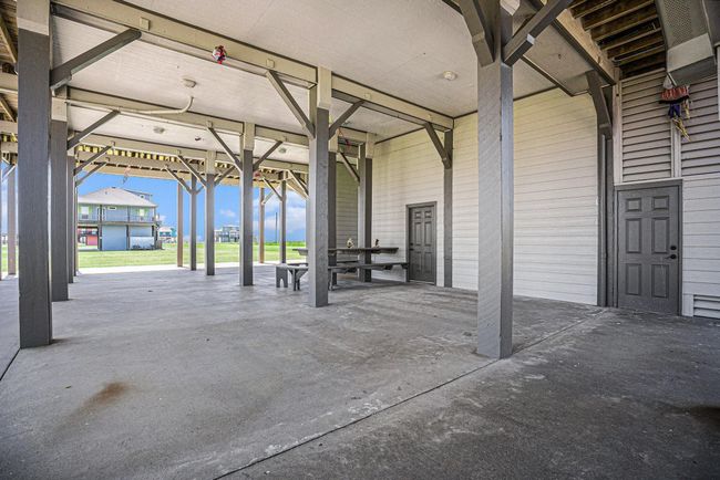 This covered outdoor area provides shelter from the elements and features a built-in picnic table, creating an ideal spot for outdoor meals and relaxation. | Image 42