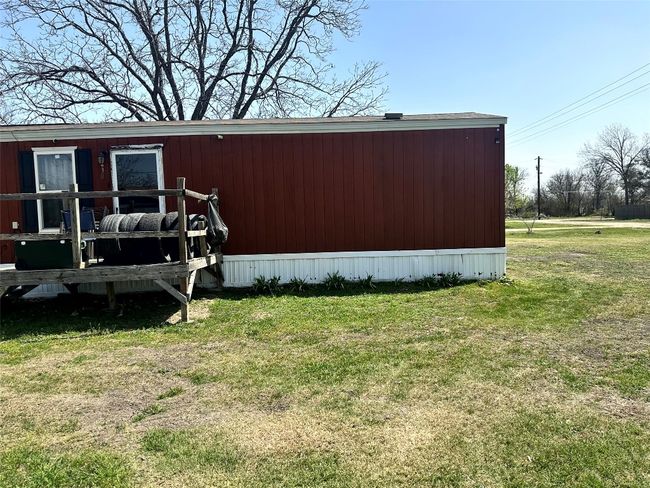 View of side of home featuring an outbuilding and a yard | Image 7