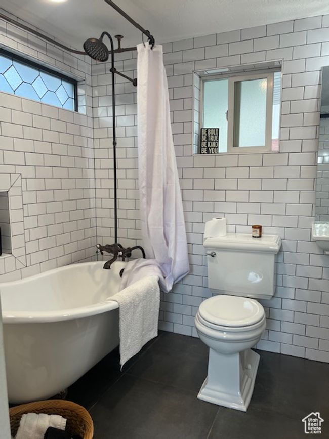 Full bathroom featuring tile walls, tile patterned flooring, and tiled shower/clawfoot bath combo | Image 17