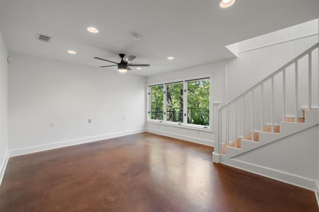 Unfurnished living room with visible vents, recessed lighting, finished concrete flooring, and stairs | Image 25