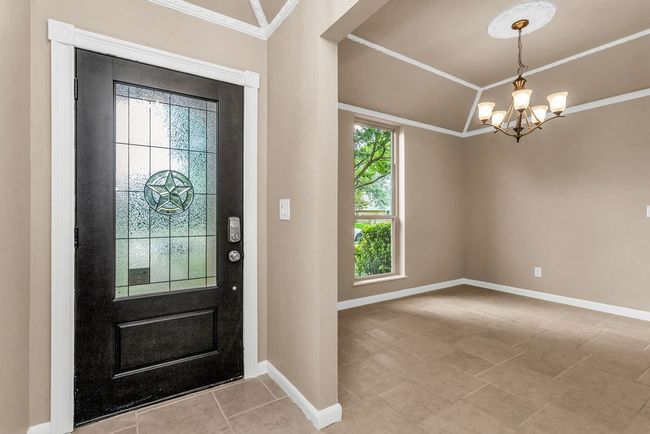Tiled entryway with a chandelier and crown molding | Image 5
