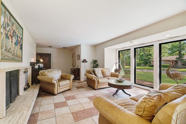Living area with a high end fireplace and light tile patterned flooring | Image 24