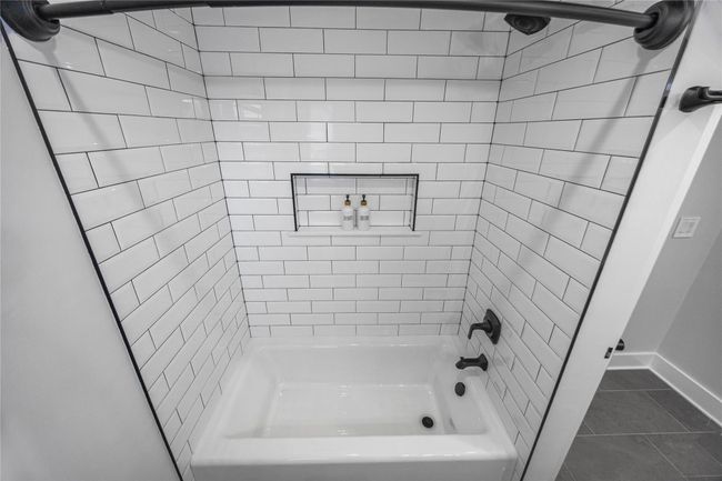 Bathroom featuring tub / shower combination, baseboards, and tile patterned floors | Image 37