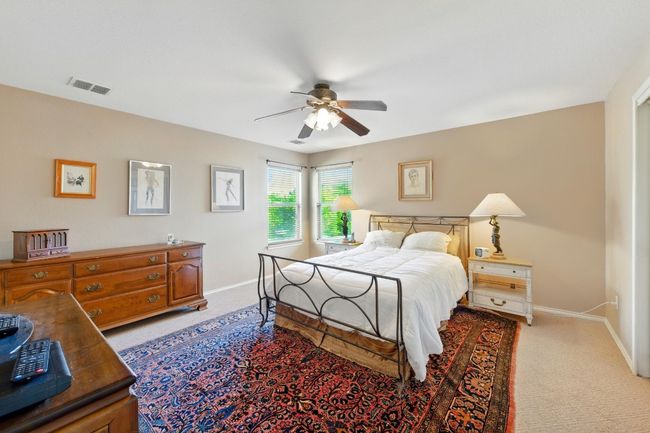 Bedroom with baseboards, light carpet, and ceiling fan | Image 18