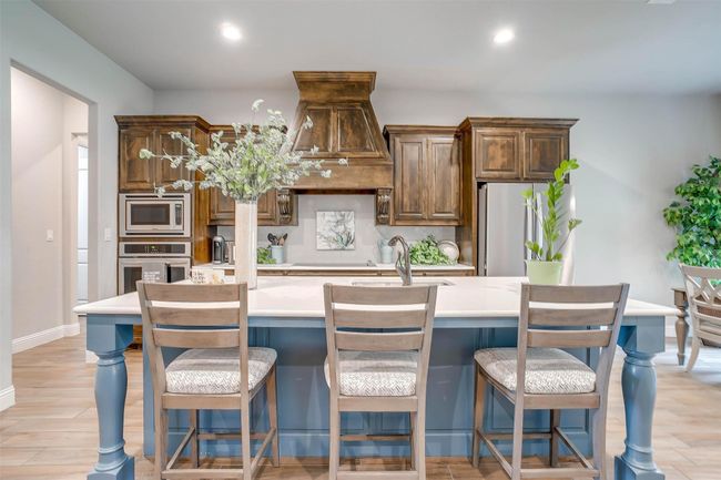 Kitchen with appliances with stainless steel finishes, light countertops, a center island with sink, backsplash, and recessed lighting | Image 16