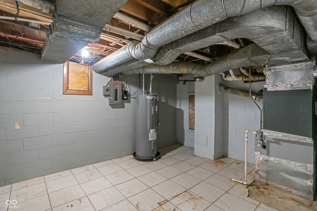 unfinished below grade area featuring water heater and electric panel | Image 38