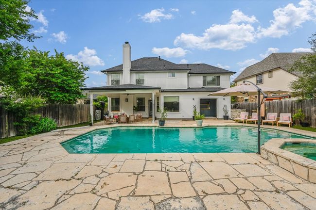 View of swimming pool with a patio area, a fenced backyard, and a pool with connected hot tub | Image 29