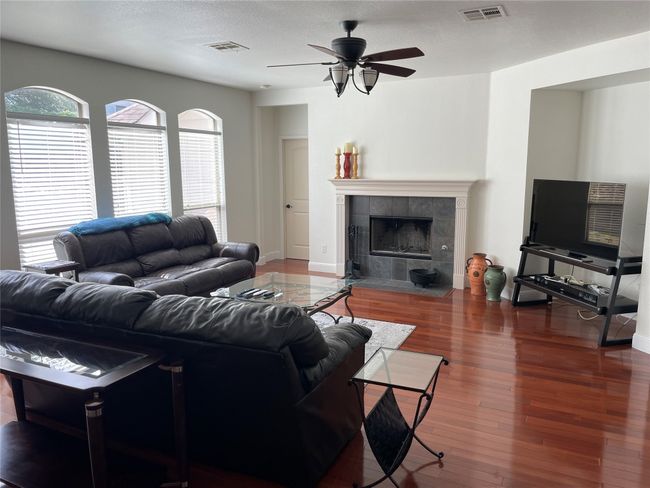 Living room with ceiling fan, healthy amount of natural light, and a tiled fireplace | Image 7