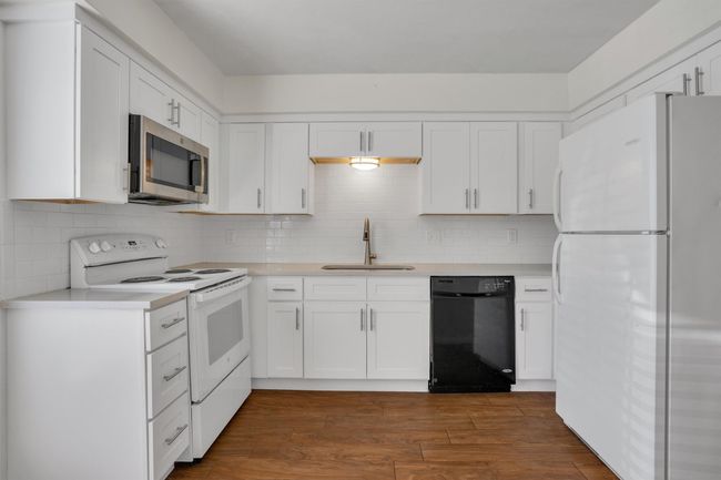 Kitchen with white appliances, white cabinetry, and light​​‌​​​​‌​​‌‌​‌‌​​​‌‌​​‌‌​‌​​​​​‌ countertops | Image 12