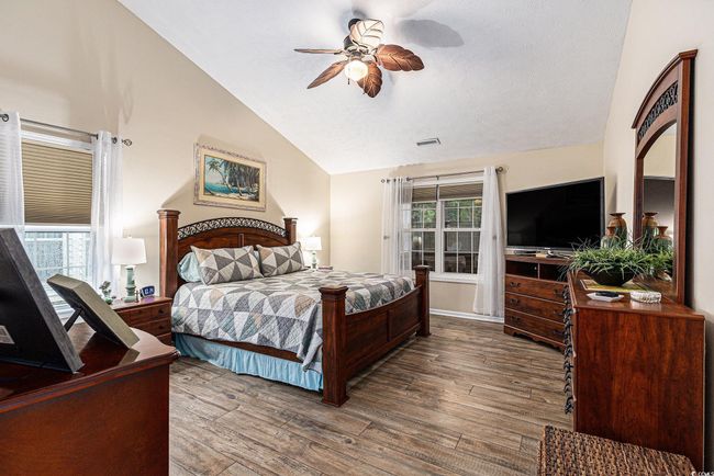 Bedroom with vaulted ceiling, wood finished floors, and a ceiling fan | Image 20