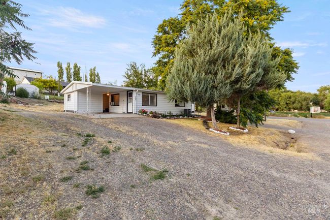 View of front of property featuring gravel driveway and a carport | Image 5