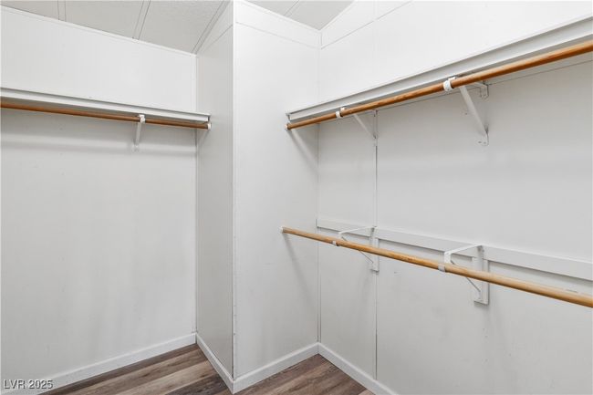 Spacious walk-in closet with light wood-style floors | Image 22