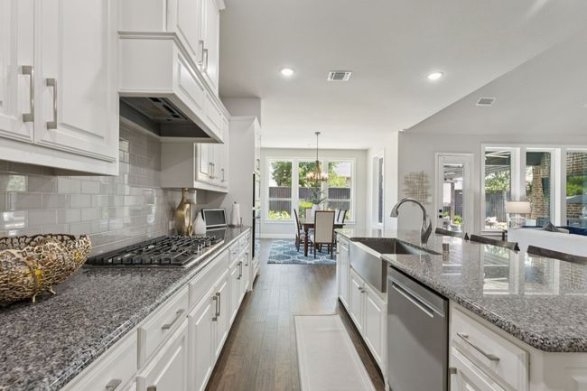 Kitchen with stainless steel appliances, dark wood finished floors, white cabinetry, and recessed lighting | Image 13