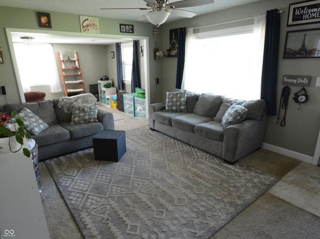living area featuring baseboards, ceiling fan, and a healthy amount of sunlight | Image 13