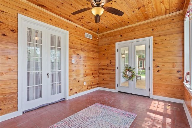 Doorway to outside with visible vents, wood walls, and french doors | Image 15
