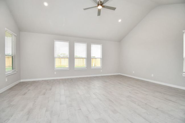 Welcome family and guests to your charming living room! With its high ceilings, recessed lighting, ceiling fan, custom paint, beautiful flooring, and large windows that let in abundant natural light, this room is perfect for gatherings. | Image 20