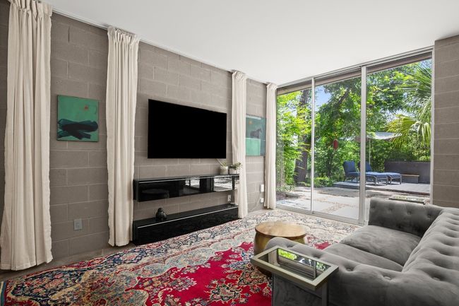 Downstairs, secondary living room with a full kitchen, full bathroom, and laundry. Can be a full guest quarters, or an entertaining area- with full floor to ceiling sliding glass doors and a private entrance to the carport, plus access to the wellness deck, back gardens, and hidden door to the alley access way. | Image 29