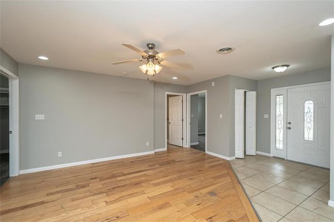 Foyer with visible vents, baseboards, light wood-type flooring, and ceiling fan | Image 8