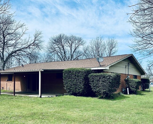 Back of property with a yard, brick siding, and central AC | Image 13