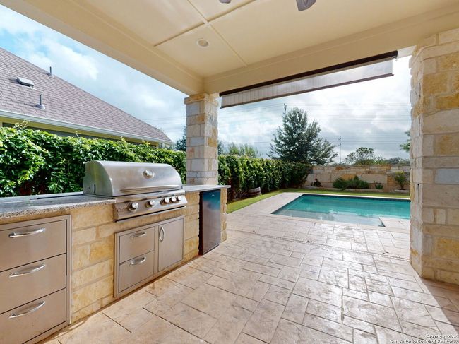 Covered back patio with gas grill and refrigerator | Image 24