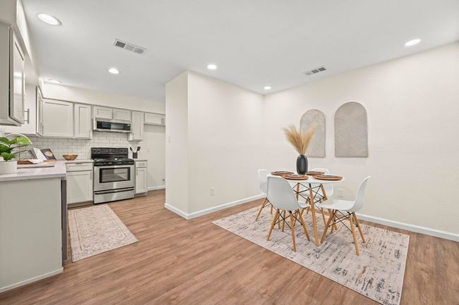 This layout, combining the kitchen, dining area, and sunroom, is ideal for entertaining. | Image 10
