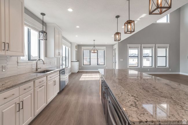 Kitchen featuring dishwasher, a chandelier, tasteful backsplash, recessed lighting, and white cabinetry | Image 11