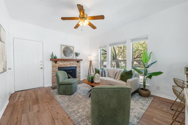 Living room featuring light wood-style floors, a brick fireplace, and a ceiling fan | Image 4