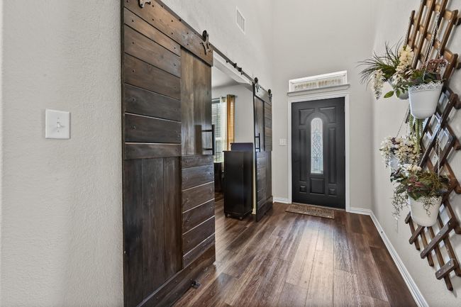 Entryway with beautiful wood barn doors and dark wood-type flooring | Image 5