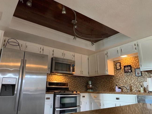 Kitchen with stainless steel appliances, white cabinetry, and a sink | Image 6