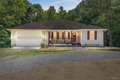 Ranch-style house featuring a garage and a porch | Image 1