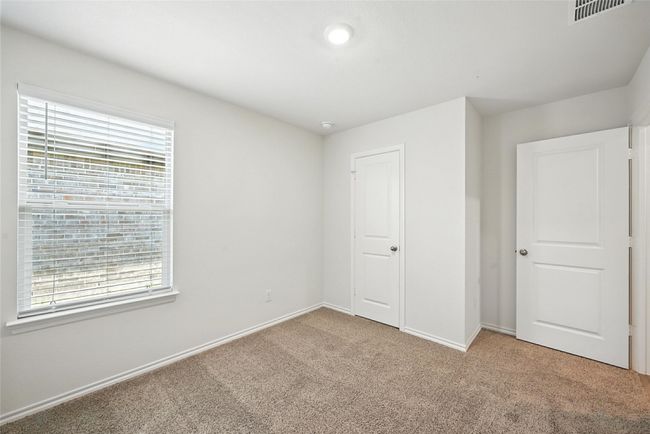 Unfurnished bedroom with light carpet and baseboards | Image 11