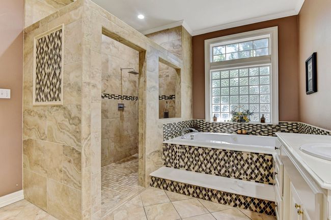 Full bath featuring plenty of natural light, a garden tub, crown molding, and walk in shower | Image 18