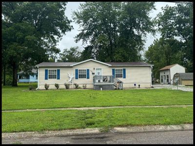 Manufactured / mobile home with a garage, a front lawn, and an outbuilding | Image 1