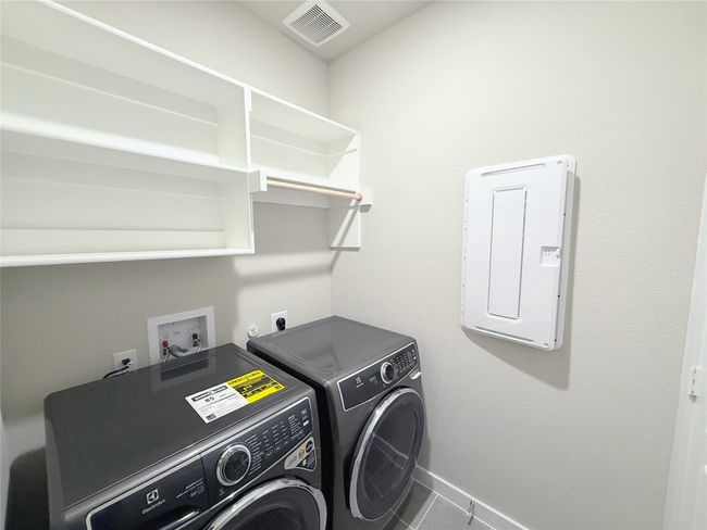 Laundry area with washer and dryer, tile patterned flooring, and electric panel | Image 25