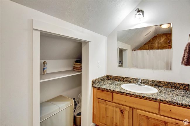 Bathroom with lofted ceiling, vanity, and a shower with shower curtain | Image 20