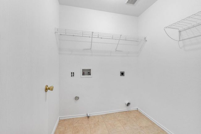 Laundry area washer hookup, baseboards, and light tile patterned flooring | Image 35