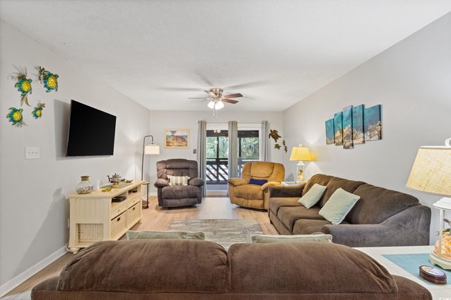 Living area with a ceiling fan, baseboards, and light wood-style floors | Image 14