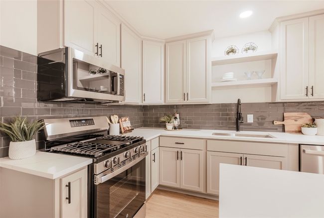 Kitchen featuring appliances with stainless steel finishes, open shelves, backsplash, light countertops, and recessed lighting | Image 9