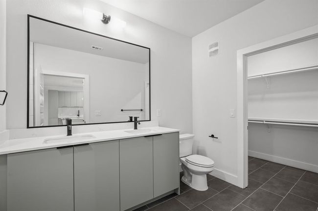 Bathroom with double vanity, tile patterned flooring, and a spacious walk-in closet | Image 15