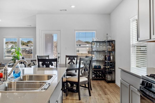 Kitchen featuring a sink, visible vents, light wood-style floors, light countertops, and gas stove | Image 13